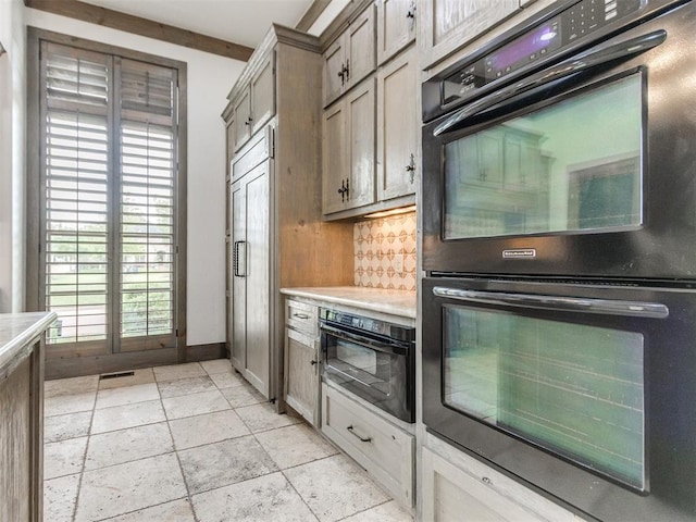 kitchen with decorative backsplash, dobule oven black, light countertops, baseboards, and paneled fridge
