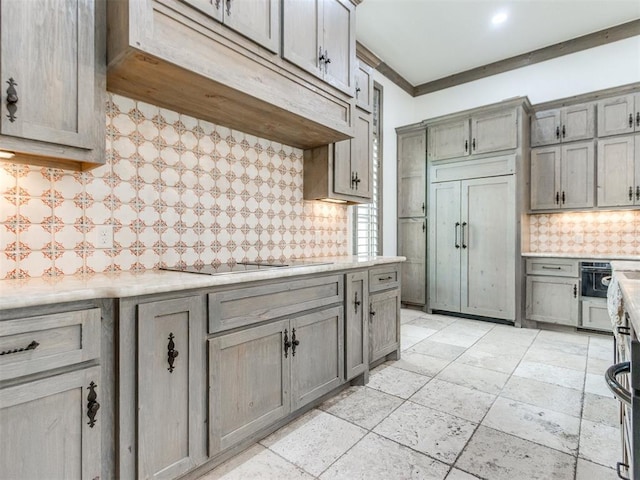 kitchen with light countertops, tasteful backsplash, gray cabinetry, and black electric stovetop