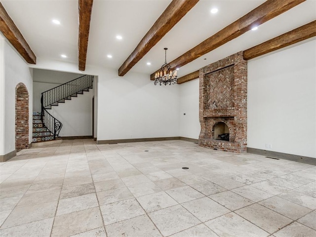 unfurnished living room featuring baseboards, stairs, beam ceiling, and a fireplace