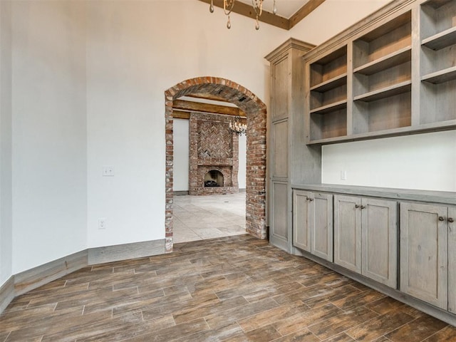 interior space featuring arched walkways, a fireplace, and dark wood-style flooring
