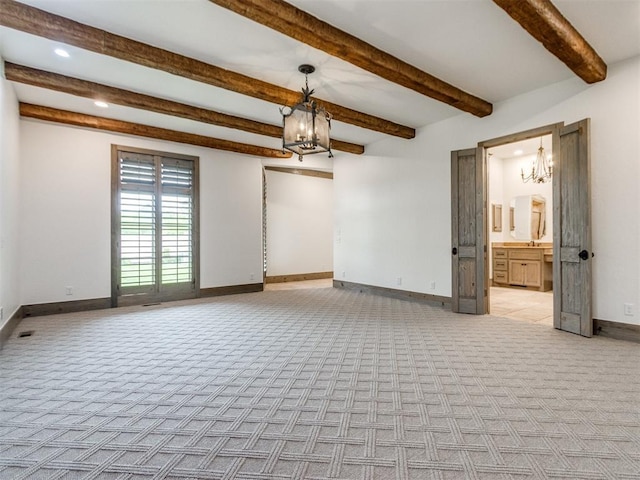 empty room featuring baseboards, light carpet, recessed lighting, and a notable chandelier
