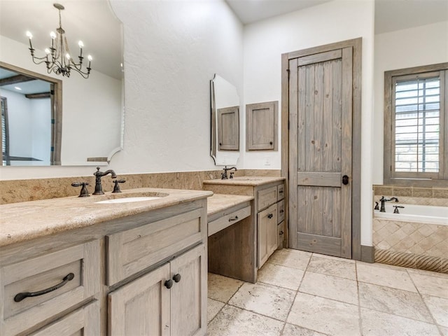 full bath featuring vanity, a bath, a chandelier, and stone tile flooring