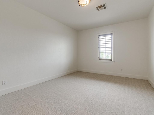 unfurnished room with visible vents, baseboards, and light carpet