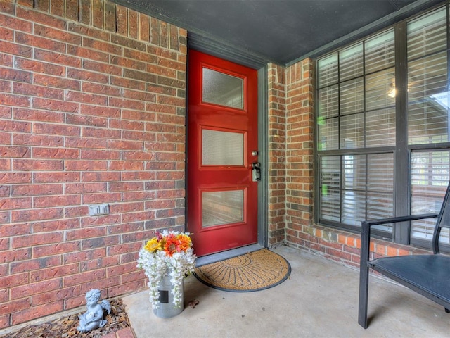doorway to property featuring brick siding