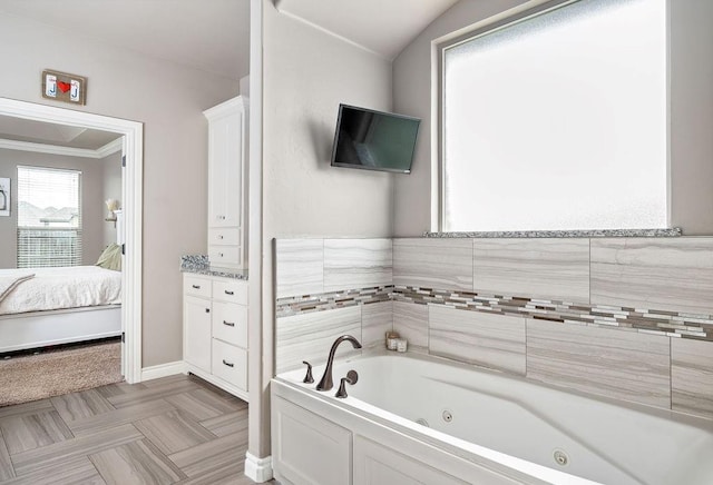 full bathroom with crown molding, baseboards, a whirlpool tub, and ensuite bath