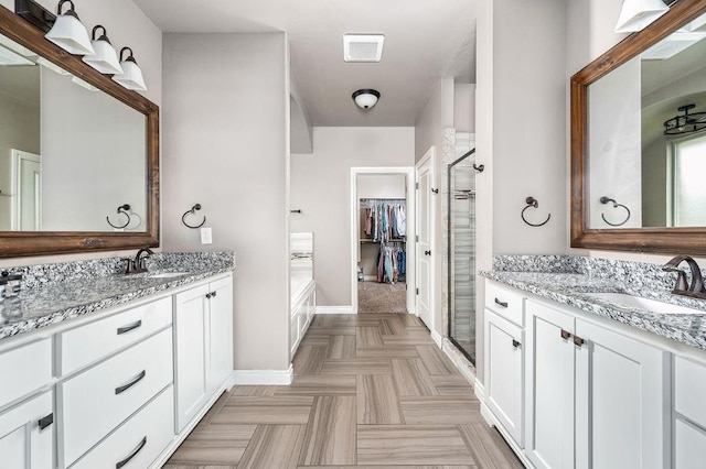 full bathroom featuring a sink, baseboards, a shower stall, and a spacious closet