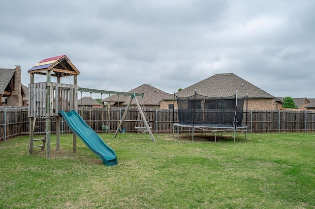 view of playground with a fenced backyard, a trampoline, and a yard