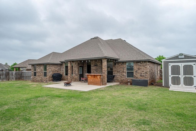 back of property featuring a patio area, brick siding, a fenced backyard, a shed, and a yard