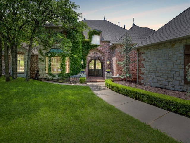 3125 Cumberland Dr, Edmond, OK 73034 - view of front of home featuring a lawn, roof with shingles, french doors, and stone siding