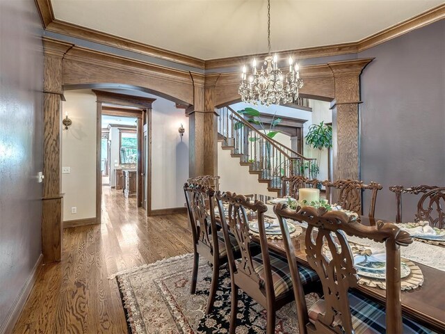 3125 Cumberland Dr, Edmond, OK 73034 - dining area with a chandelier, crown molding, wood finished floors, arched walkways, and baseboards