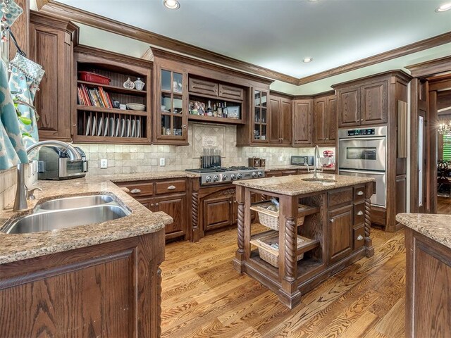 3125 Cumberland Dr, Edmond, OK 73034 - kitchen with open shelves, a sink, stainless steel appliances, light wood-style flooring, and ornamental molding