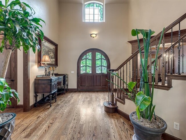 3125 Cumberland Dr, Edmond, OK 73034 - foyer entrance with stairway, a high ceiling, wood finished floors, and baseboards