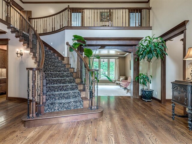 3125 Cumberland Dr, Edmond, OK 73034 - stairs with ornamental molding, wood finished floors, baseboards, and arched walkways