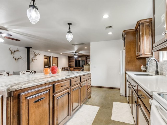 kitchen with ceiling fan, a sink, white appliances, decorative light fixtures, and visible vents