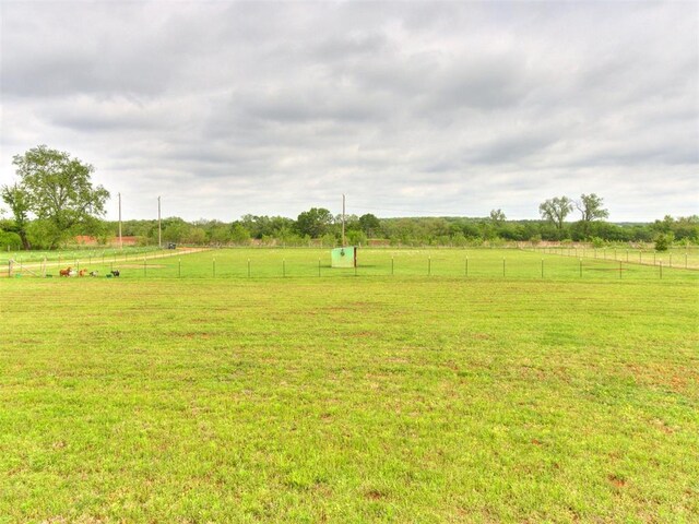 view of yard featuring a rural view and fence