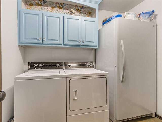laundry room with cabinet space and washer and clothes dryer