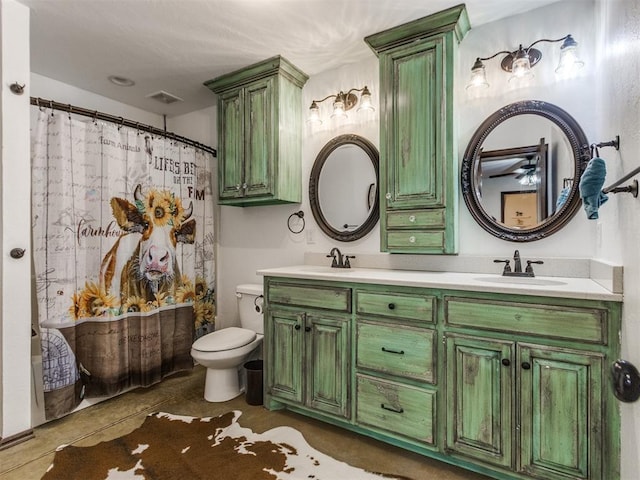 bathroom with a sink, toilet, double vanity, and visible vents