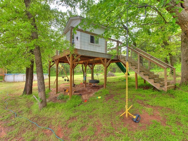 exterior space featuring stairs, a deck, and an outdoor pool