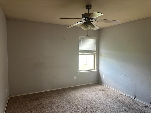 spare room with carpet flooring, ceiling fan, and baseboards
