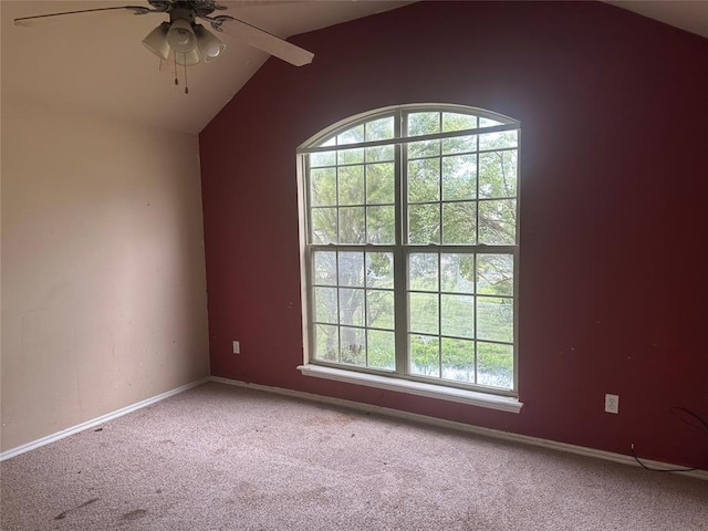 carpeted spare room with a ceiling fan, baseboards, and vaulted ceiling