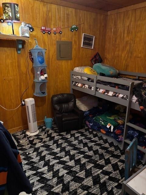 bedroom featuring wood walls and electric panel