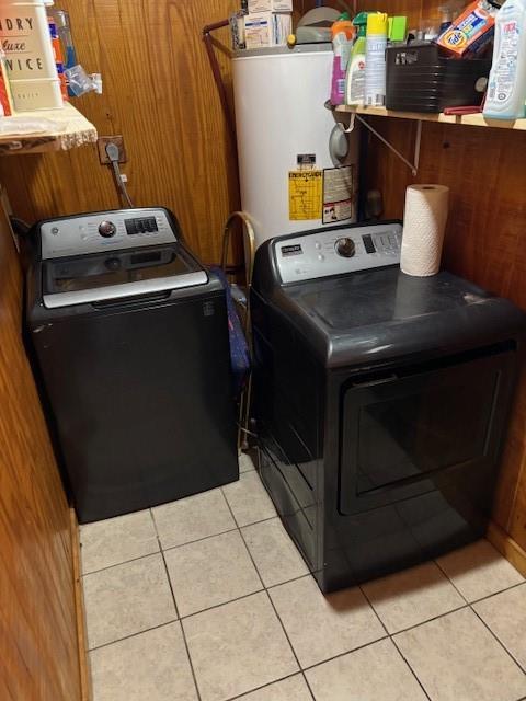 923 N 3rd St, Okemah, OK 74859 - laundry room with washing machine and clothes dryer, wood walls, light tile patterned floors, and water heater