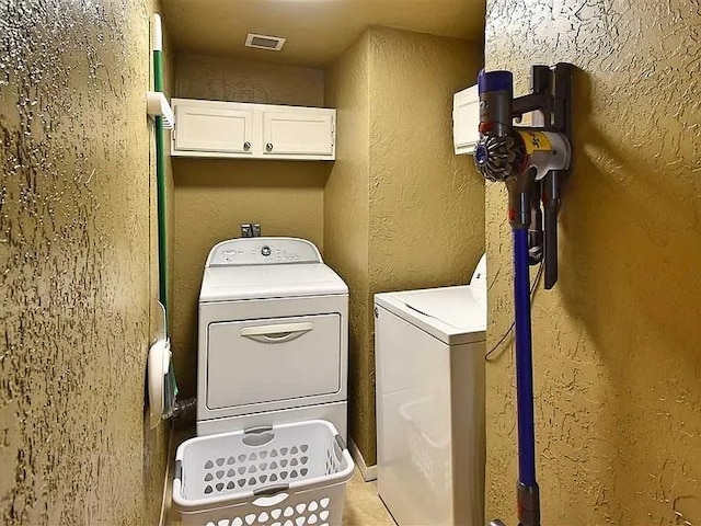 1904 NW Euclid Ave, Lawton, OK 73507 - clothes washing area with cabinet space, a textured wall, visible vents, and washing machine and dryer