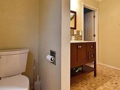 1904 NW Euclid Ave, Lawton, OK 73507 - bathroom featuring toilet, baseboards, and vanity