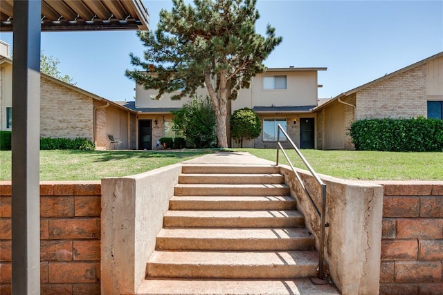 view of front of property featuring brick siding and a front lawn