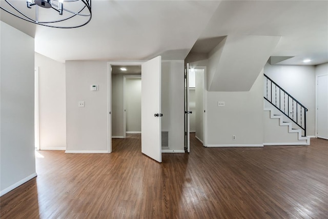 unfurnished living room with baseboards, dark wood-style floors, stairway, and visible vents