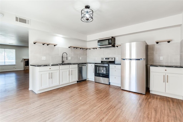 kitchen featuring visible vents, open shelves, dark countertops, appliances with stainless steel finishes, and backsplash