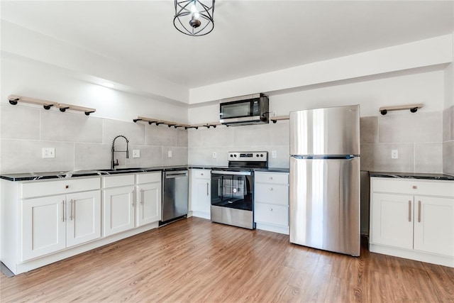 kitchen with open shelves, tasteful backsplash, dark countertops, and stainless steel appliances