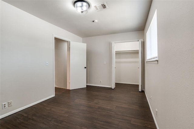unfurnished bedroom featuring visible vents, baseboards, wood finished floors, and a closet