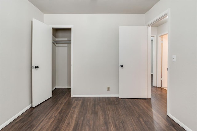 unfurnished bedroom with baseboards, a closet, and dark wood-style floors