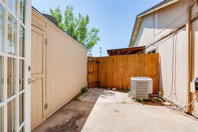 view of patio / terrace featuring central air condition unit and fence