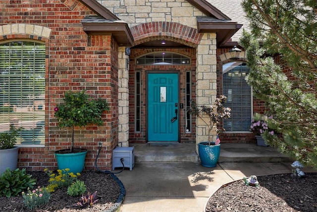 doorway to property featuring stone siding and brick siding