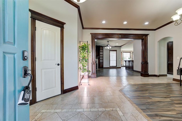 entrance foyer featuring a ceiling fan, arched walkways, baseboards, ornamental molding, and recessed lighting