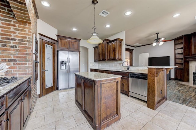 kitchen with visible vents, a sink, a peninsula, a ceiling fan, and appliances with stainless steel finishes