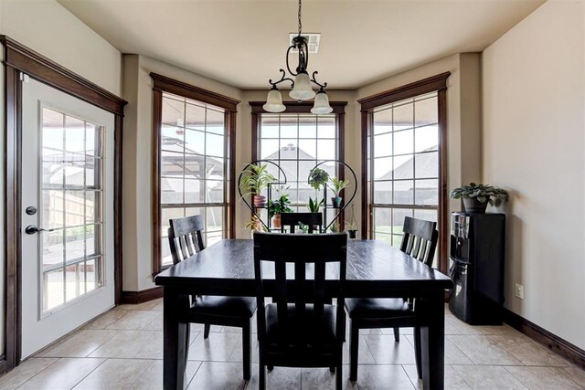 dining room featuring light tile patterned floors, baseboards, visible vents, and a wealth of natural light