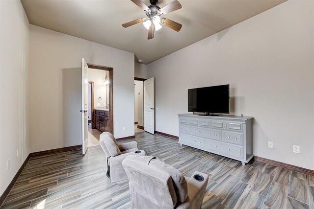 bedroom featuring baseboards, a ceiling fan, ensuite bath, and wood finished floors