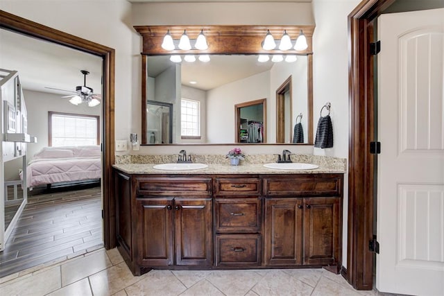 ensuite bathroom featuring ceiling fan, plenty of natural light, and a sink