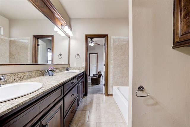 full bathroom with a sink, tile patterned flooring, ceiling fan, and double vanity