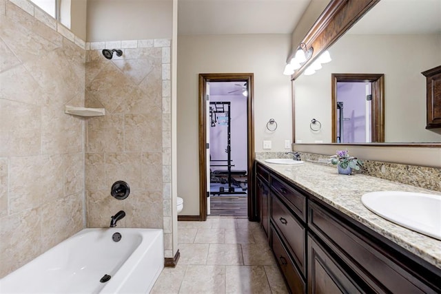 full bath with double vanity, toilet, a sink, and tile patterned flooring