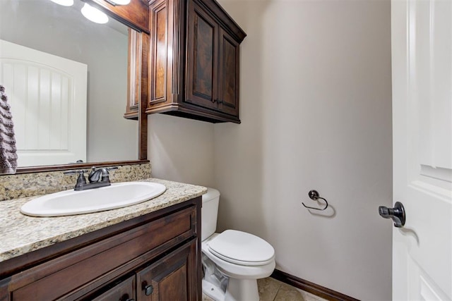 bathroom with tile patterned flooring, baseboards, toilet, and vanity