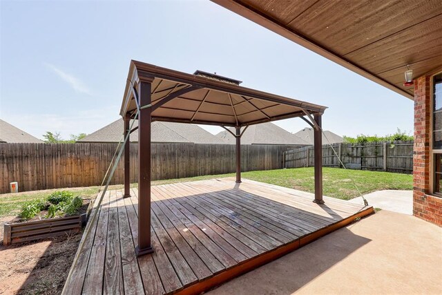 wooden deck featuring a lawn, a gazebo, and a fenced backyard
