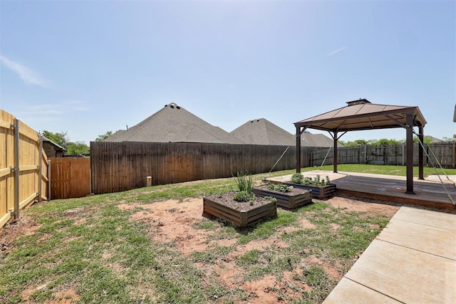 view of yard featuring a gazebo, a garden, and a fenced backyard