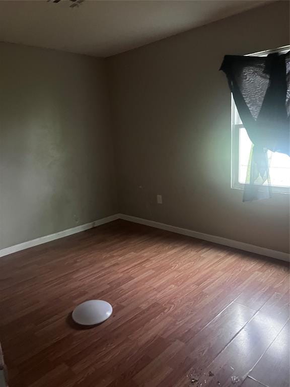 empty room with wood finished floors and baseboards