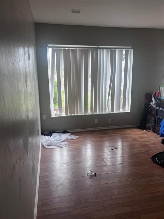 empty room with a wealth of natural light and wood finished floors