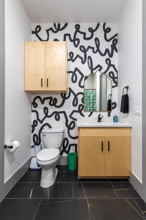 bathroom featuring baseboards, tile patterned flooring, vanity, and toilet