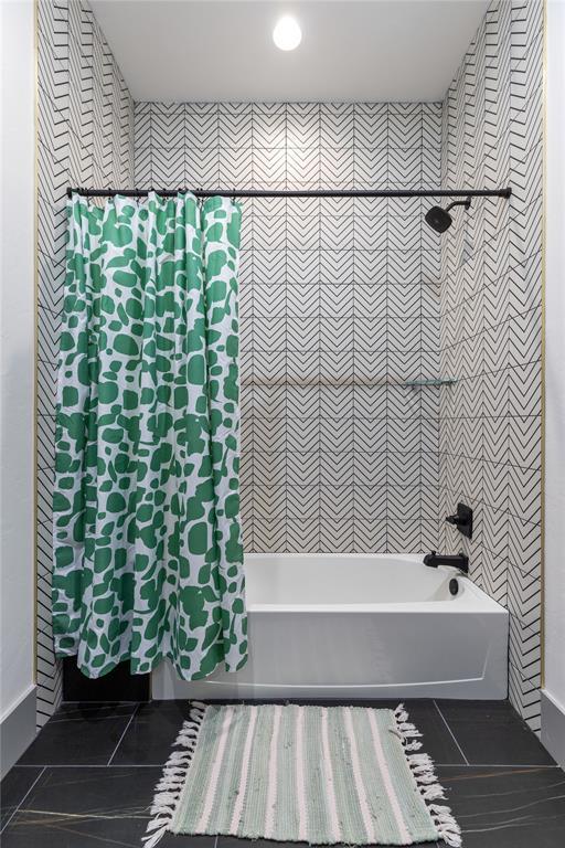 full bathroom featuring wallpapered walls, shower / bathtub combination with curtain, and tile patterned flooring